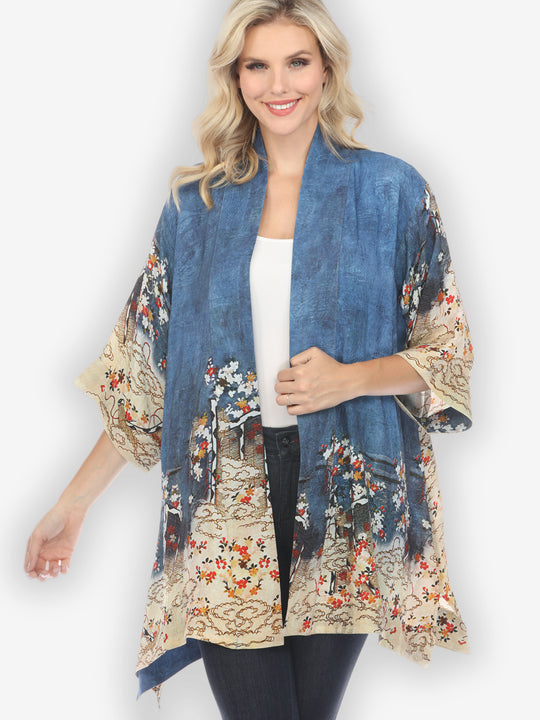 A woman wearing a blue kimono jacket with floral patterns. The jacket has an open front and it&