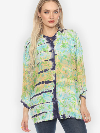Woman wearing a colorful floral blouse against a white background