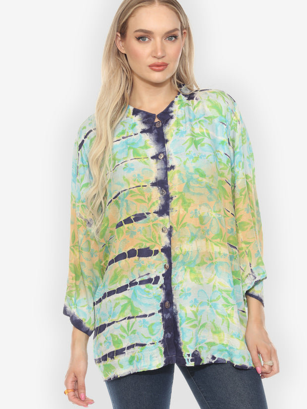 Woman wearing a colorful floral blouse against a white background