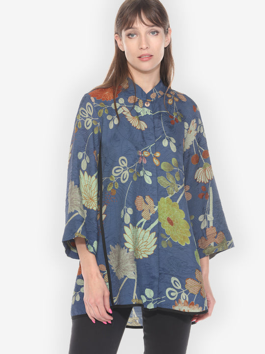 Woman wearing a blue floral patterned shirt on a white background